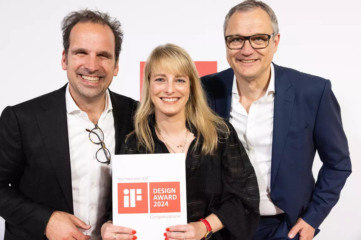 Preisverleihung des iF Design Awards 2024. Die strahlenden Geschäftsführer von &MICA Andreas Michels und Thorsten Schmedt stehen neben der glücklichen Geschäftsführerin von Büro Schramm für Gestaltung, Stephie Schramm. Alle lächeln in die Kamera mit der Urkunde in der Hand.