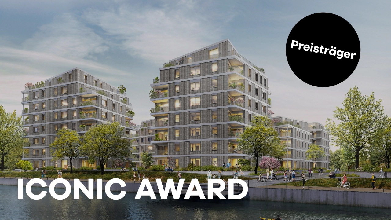 Visualisierung einer modernen Wohnanlage mit mehreren sechsstöckigen Gebäuden in nachhaltiger Architektur. Die Fassade besteht aus Holz und Beton, während große Balkone mit viel Grün die Gebäude schmücken. Im Vordergrund ein Wasserkanal mit Spaziergängern, Radfahrern und Bäumen entlang der Promenade. Ein schwarzer Kreis mit der Aufschrift „Preisträger“ hebt die Auszeichnung des Projekts hervor. Unten im Bild steht in großen weißen Buchstaben „ICONIC AWARD“.
