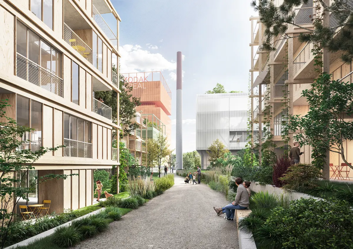 Visualisierung eines begrünten Quartiersweges im Kodak-Areal mit Holzfassaden, Balkonen und dem erhaltenen historischen Fabrikschornstein.